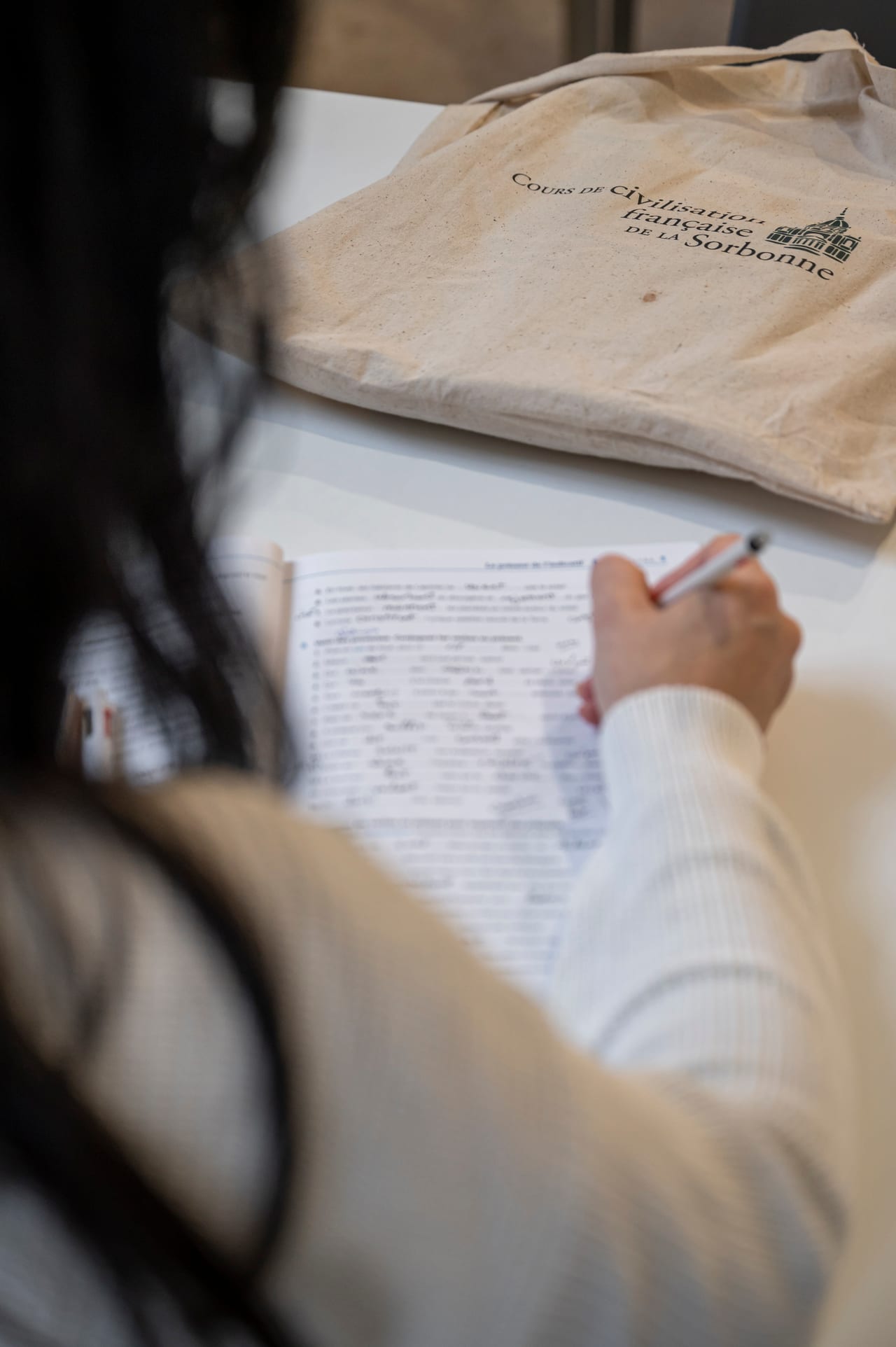 Étudiante CCFS prenant des notes, tote bag officiel des Cours de Civilisation Française de la Sorbonne